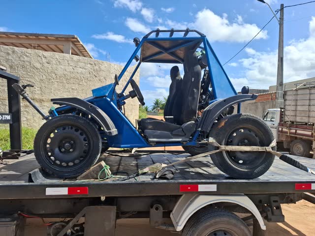 Buggy de trilha azul sobre a plataforma do reboque da Adsumus