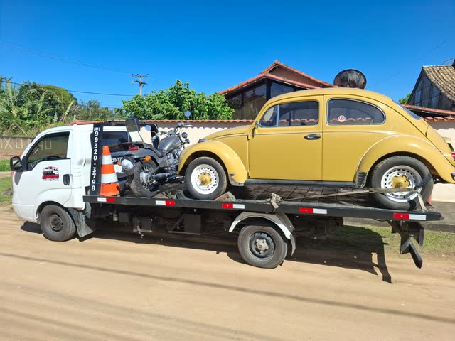 Fusca antigo e uma moto custom juntos na plataforma do reboque da Adsumus