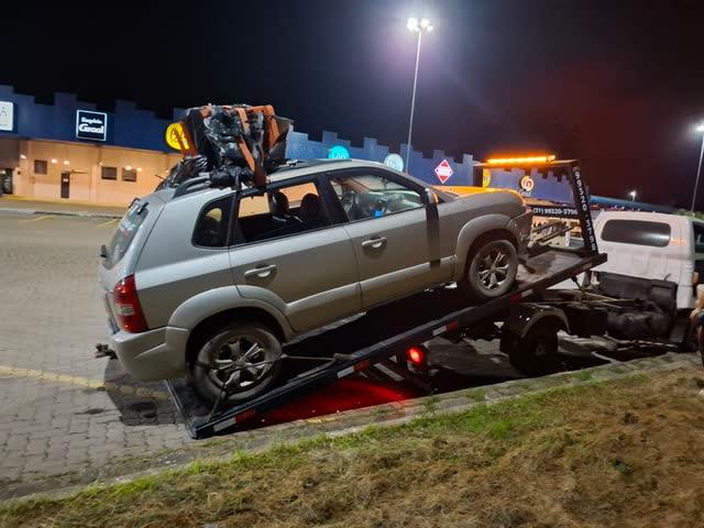 Reboque da Adsumus com um SUV na plataforma durante atendimento noturno em um posto